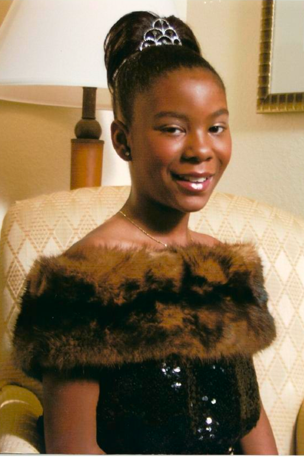 Maiya Cunningham smiling, wearing a brown fur wrap and tiara.